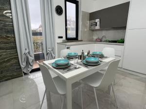 een witte keuken met een witte tafel en stoelen bij RESIDENCE MARCO POLO in Montesilvano