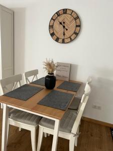 a dining room table with a clock on the wall at „Main“ Zuhause in Kleinheubach