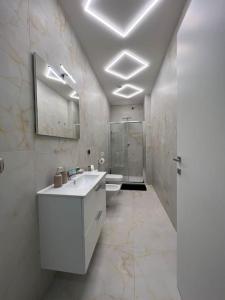 een witte badkamer met een wastafel en een douche bij RESIDENCE MARCO POLO in Montesilvano