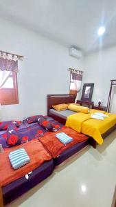 dwa łóżka siedzące obok siebie w sypialni w obiekcie Omah Tabon Jogja - Dekat Dengan Malioboro w mieście Timuran