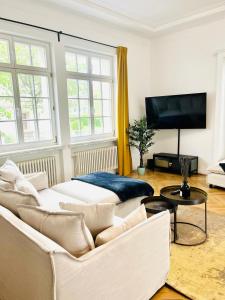 een woonkamer met 2 banken en een flatscreen-tv bij Luxusapartment im Dichterviertel *Garten*Parkplatz*Wifi* in Erfurt