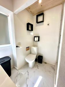 Baño blanco con aseo y suelo de mármol en Cantinho da Verdade, en Odiáxere