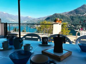 a blue table with a view of the mountains at Terrace Lake View Moltrasio in Moltrasio