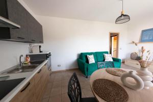 Il comprend une cuisine et un salon avec une table et un canapé. dans l'établissement Vistaverde Harmony Apartments, à Cavaion Veronese