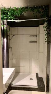 een wit betegelde badkamer met een douche en een wastafel bij Leben am Dortmunder U in Dortmund