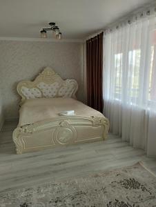 Ce lit se trouve dans une chambre dotée d'une grande fenêtre. dans l'établissement Hotel Ketmen Tobo, à Dzhangi-Dzhol