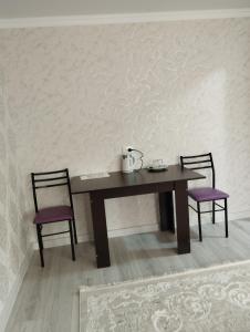 - une table avec 2 chaises et une bouilloire dans l'établissement Hotel Ketmen Tobo, à Dzhangi-Dzhol