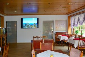 a dining room with a tv on the wall at Landhotel Kunzental in Zorge