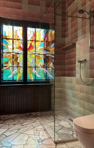 a bathroom with a stained glass window and a toilet at Willa no.18 in Reda