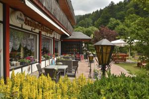 ein Restaurant mit einer Terrasse mit Tischen und Stühlen in der Unterkunft Landhotel Kunzental in Zorge