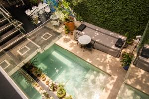 uma vista superior para uma piscina com uma mesa e cadeiras em Cosmopolitano Hotel Boutique em Santa Cruz de la Sierra