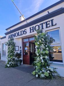 a building with flowers in front of a hotel at Arnolds Hotel in Dunfanaghy
