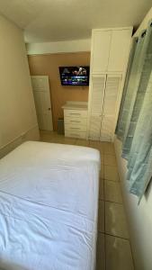 a bedroom with a bed and a tv on the wall at Multigen-Lip of the City Escape in Castries