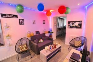 een woonkamer met een roze muur met ballonnen en een bank bij Expérience INSOLITE ! ROMANTIQUE / ESCAPE GAME in Lizy-sur-Ourcq