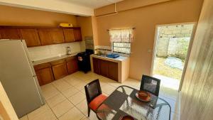 a kitchen with a table and chairs and a kitchen with a window at Multigen-Lip of the City Escape in Castries