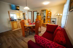 a living room with a red couch and a table at Gemütliches Haus mit Terasse und Feuerstelle in Lengnau