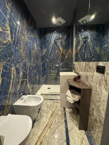 a bathroom with a sink and a toilet and a tub at KUDETÀ SUITE in Campobasso