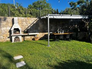 a stone pizza oven in a yard with a table and chairs at Meridiem Holiday Home in Dubrovnik region in Gruda