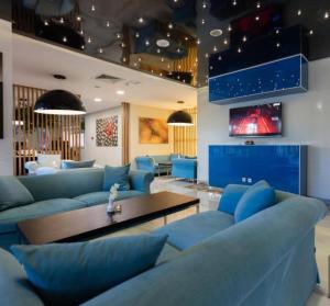 Una sala de estar con sofás azules y una mesa. en Premier Lux apartmán, en Sveti Vlas