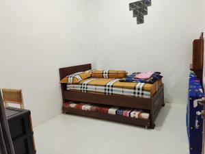 Bett in einer Ecke eines Zimmers in der Unterkunft Harmony Resto&Homestay in Lambangkuning