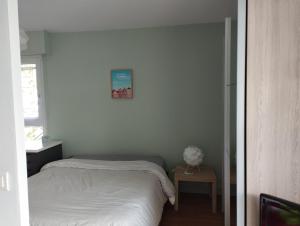 Dormitorio pequeño con cama y mesa en T1 bis 32 m2 avec terrasse et exposé sud, idéal pour vacances et/ou télétravail, en Vannes