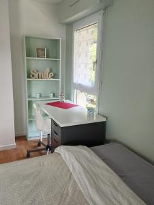 1 dormitorio con cama, escritorio y ventana en T1 bis 32 m2 avec terrasse et exposé sud, idéal pour vacances et/ou télétravail, en Vannes