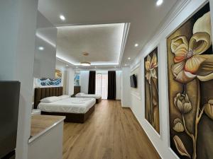 een kamer met 2 bedden en een schilderij aan de muur bij Bamisa Apartments in Golem