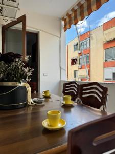een eettafel met gele kopjes en schotels erop bij Bamisa Apartments in Golem