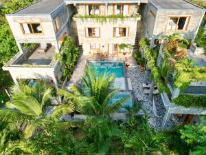 an aerial view of a house with a swimming pool and palm trees at Hermanos Perdidos Surf in Las Tunas