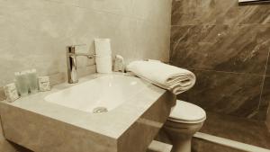 a bathroom with a sink and a toilet at Masaya Al Deyar Apartments in Amman