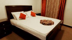 a bedroom with a bed with orange and white pillows at Masaya Al Deyar Apartments in Amman