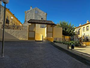 una calle adoquinada frente a un edificio en Casa Rural Familiar , Castilleja del Campo , Sevilla, en Sevilla