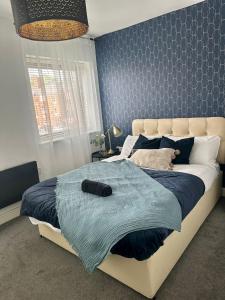 een slaapkamer met een groot bed en een blauwe deken bij 2 Bed Luxury Apartment With 1 FREE Uber Eats Meal in Wolverhampton