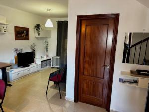 sala de estar con puerta de madera y TV en Casa Rural Familiar , Castilleja del Campo , Sevilla, en Sevilla