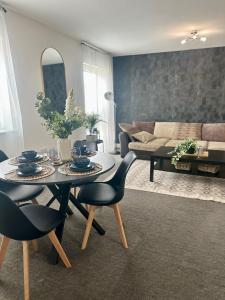 2 Bed Luxury Apartment With 1 FREE Uber Eats Meal في ولفرهامبتون: غرفة معيشة مع طاولة وكراسي وأريكة