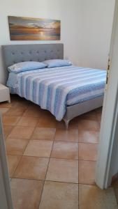 1 dormitorio con 1 cama y suelo de baldosa en Appartamento in residence fronte mare, en Murta Maria