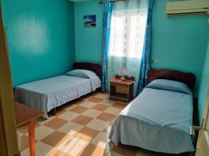 two beds in a room with blue walls at Villa Bungaroo in Pereybere