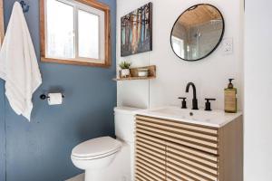 uma casa de banho com um WC, um lavatório e um espelho. em A-frame Cottage Lakeside, Charleston lake 
