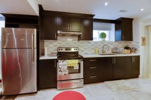 a kitchen with brown cabinets and a stainless steel refrigerator at Large Unit with free parking, Wifi, 25 minutes to Downtown Toronto in Toronto
