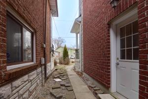 an alley between two brick buildings with a white door at Large Unit with free parking, Wifi, 25 minutes to Downtown Toronto in Toronto