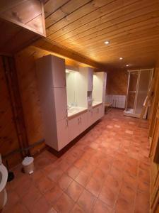 uma cozinha com armários brancos e piso em azulejo em La Casa Marrone Norway em Asker