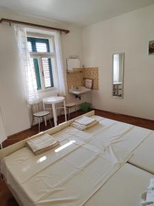 a large bed in a room with a table at Guesthouse Franko in Vela Luka