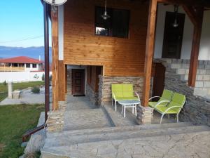 una casa con sillas verdes en el porche en Vila agapi -Вила Любов en Elhovo