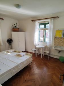 a bedroom with a bed and a table and a window at Guesthouse Franko in Vela Luka