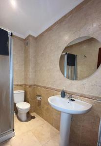 bagno con lavandino, servizi igienici e specchio di Apartamento Verano a Mugardos