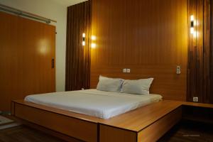 a bedroom with a large bed with a wooden headboard at Le VÏU STUDIO 3 in Cotonou