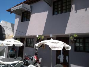 a scooter parked in front of a building with two umbrellas at Apartamento e Suítes Mobiliada Climatizada Campo Grande in Recife