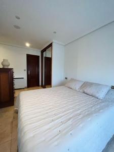 un grande letto bianco in una camera da letto bianca di Apartamento Verano a Mugardos