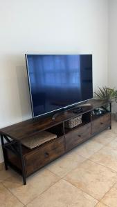 una grande TV a schermo piatto su un centro di intrattenimento in legno di Apartamento Verano a Mugardos