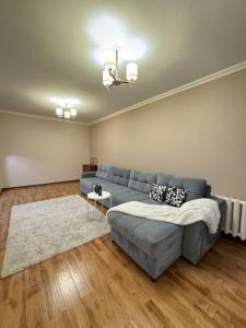sala de estar con sofá azul y alfombra en Квартира, en Prigorodnyy